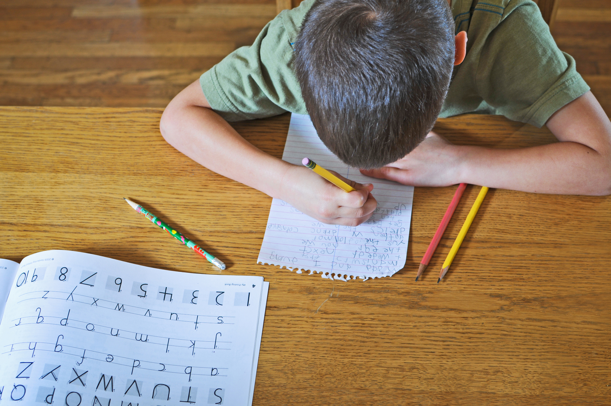 Ni&ntilde;o practicando su escritura en la tarea.