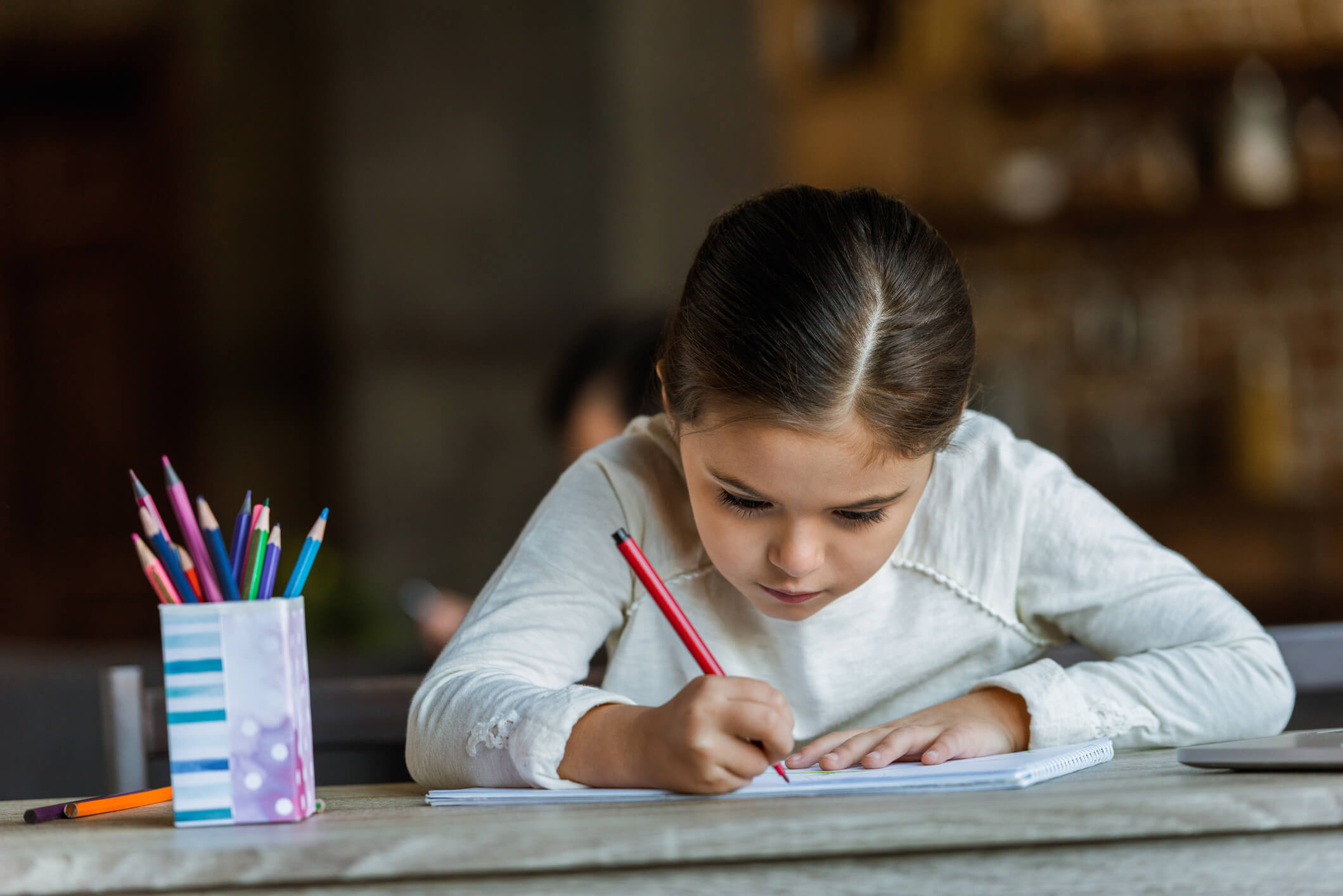Ni&ntilde;a con disgrafia realizando ejercicios en casa.